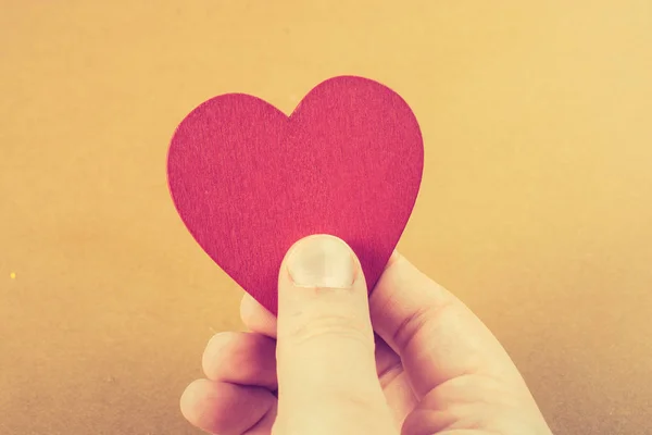 Color rojo objeto en forma de corazón en la mano —  Fotos de Stock