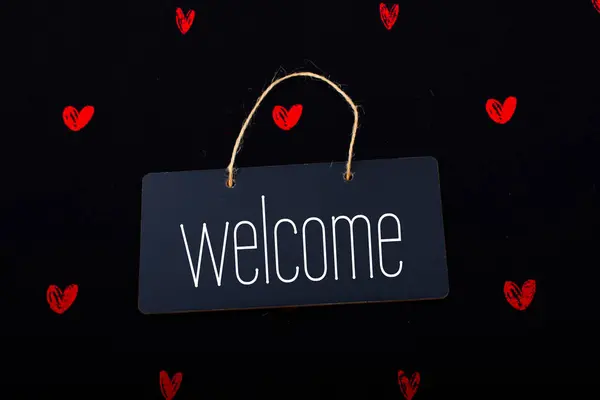 Welcome on black notice board  with red hearts around — Stock Photo, Image