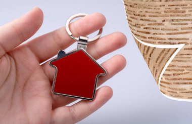 Arka planda ev simgesi tutan el