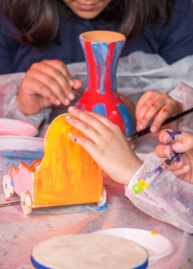 Çocuklar masaya resim çizer ve resim yapar.