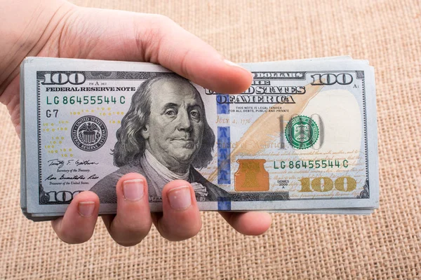 Держа в руках банкноту в долларах США — стоковое фото