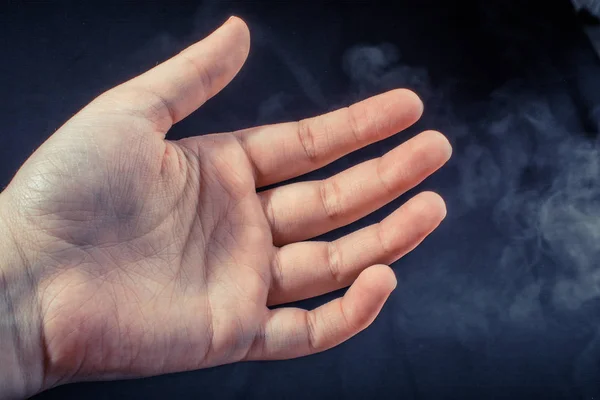 Рука робить жест на чорному диму фоні — стокове фото