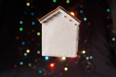 Koyu arkaplanda Bokeh ışıkları olan küçük model ev.