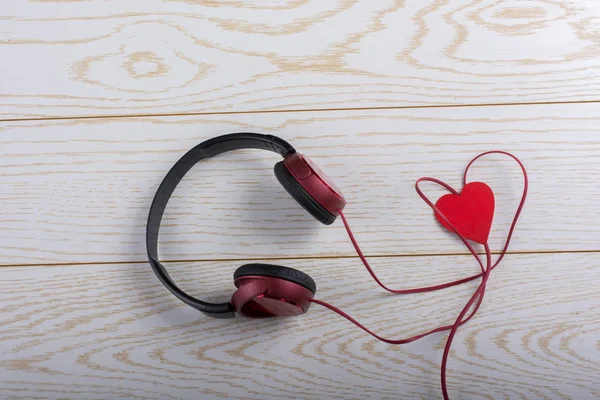 Red heart and red headphones on wooden background — Stock Photo, Image