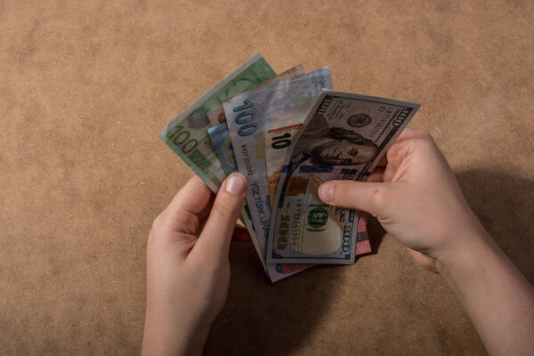 Hand holding American dollar  isolated on wooden background