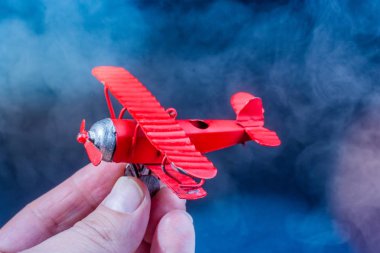 Siyah arka plan üzerinde oyuncak düzlem tutan el