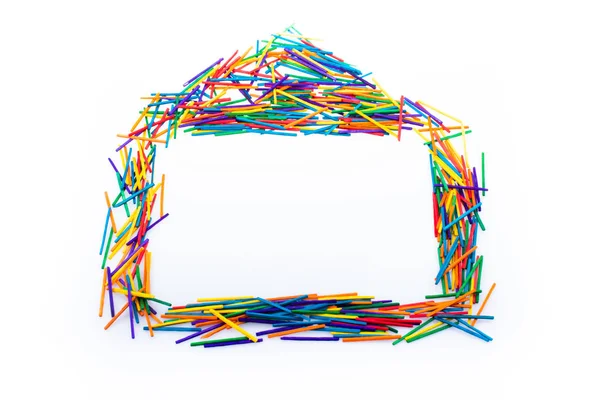 Renkli çubuklardan yapılmış ev şekli, yaratıcı konsept.