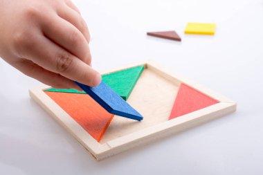 Tangram bulmacasının kayıp parçasını tutan el.