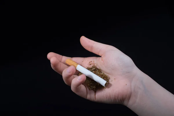 Hand håller en cigarett på svart bakgrund — Stockfoto