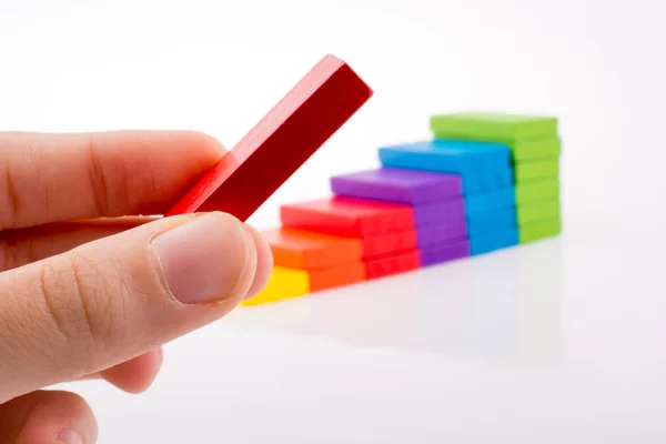 Mano jugando con dominó de colores — Foto de Stock