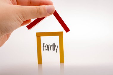  Aile etiketi ile bir ev oluşturan el tutan domino