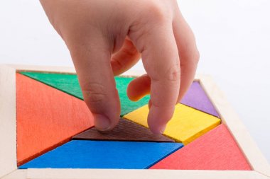 Tangram bulmacasının kayıp parçasını tutan el.