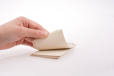 Beyaz arkaplanda elle tutulan spiral defter