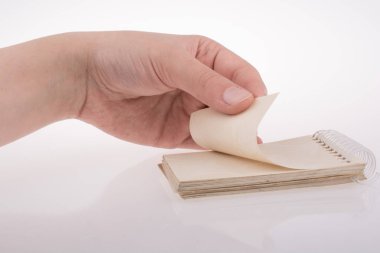 Beyaz arkaplanda elle tutulan spiral defter