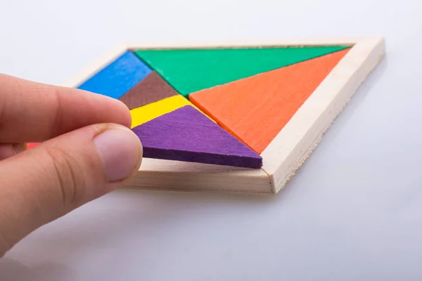 Hand houden van een ontbrekende stuk in een tangram puzzel — Stockfoto
