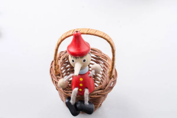Pinochio Spielzeugfigur sitzt in einem Korb — Stockfoto