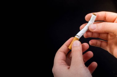 El siyah arka plan üzerine bir sigara kırılıyor