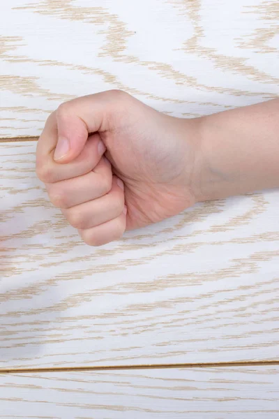 Hands making rock, paper, scissors gesture on wooden background