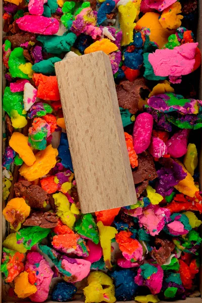 Piece of wood on dried colorful play dough — Stock Photo, Image
