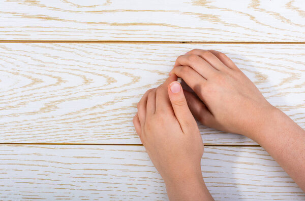 Hands making a gesture on wooden background