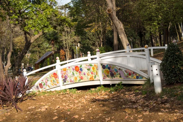 Hölzerne weiße Brücke mit bunten Blumen darauf — Stockfoto