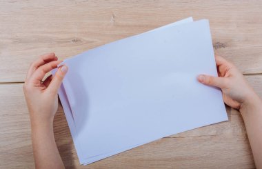 Ahşap arka planda kağıt el tutma levhalar