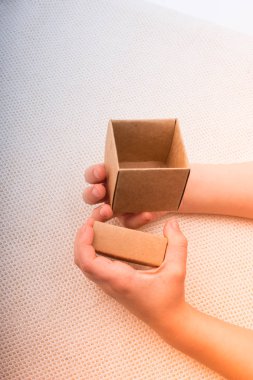 Beyaz bir arkaplanda el ele tutuşan karton kutu 