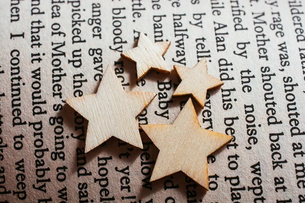 Pequeñas estrellas de madera en la página del libro —  Fotos de Stock