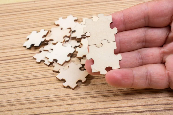 Рука чоловіка, який намагається з'єднати шматочки головоломки — стокове фото