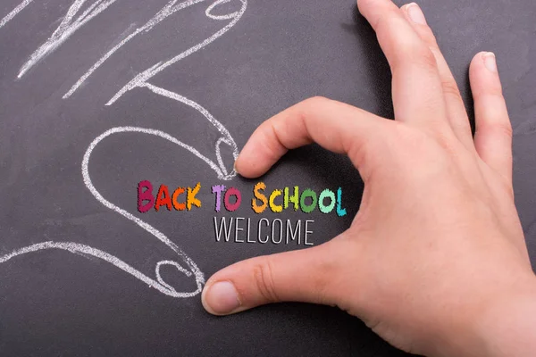 Handen vormen een hart op schoolbord — Stockfoto