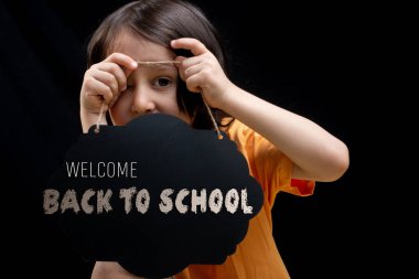 Küçük çocuk elinde boş bir reklamcılık işareti kurulu tutan