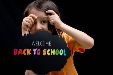 Küçük çocuk elinde boş bir reklamcılık işareti kurulu tutan