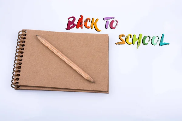 Pencil placed on a notebook on white background — Stock Photo, Image