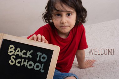 beyaz arka plan üzerinde bir tahta tutan küçük çocuk