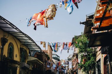 Bir sokakta bir giysi hattı ipinden sarkan kıyafetler