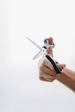 Beyaz bir backgruond üzerinde el tutan makas