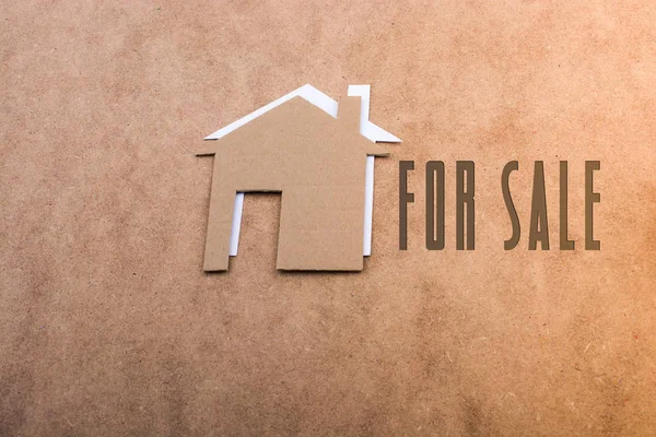 Till salu etikett beisde papper hus på brun — Stockfoto