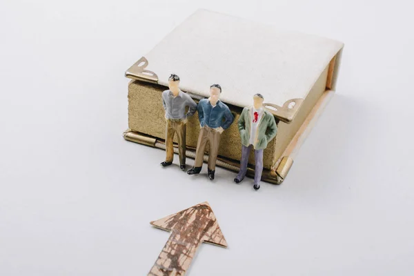 Estatueta minúscula de modelos de homens ao lado de um livro — Fotografia de Stock