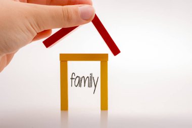 Aile etiketi ile bir ev oluşturan el tutan domino