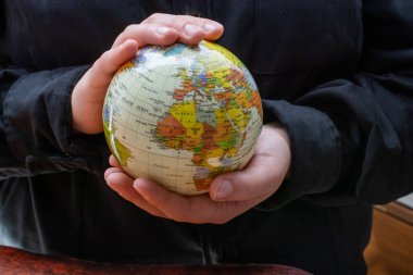 Elleriyle bir dünya modeli tutan kişi.