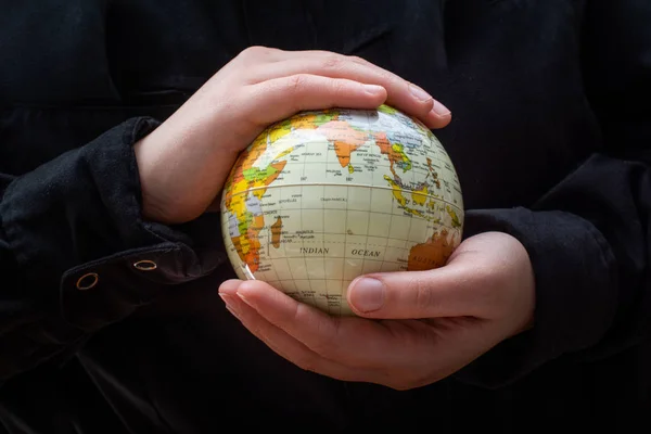 Person holding a globe model with hands — 스톡 사진