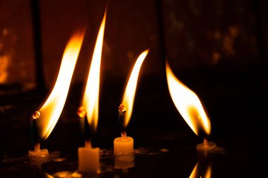 Mumlar karanlıkta alevlerle yanıyor. 