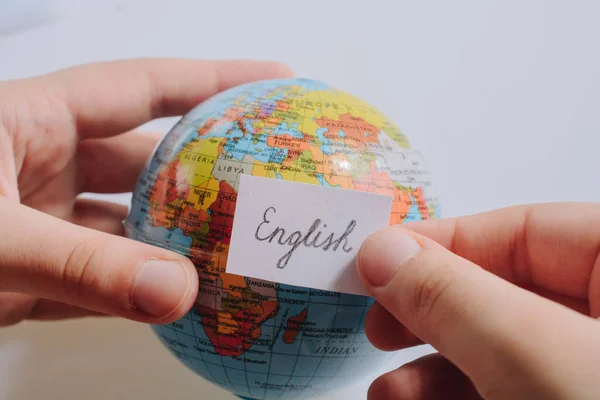 Caderno de mão com redação em inglês no globo — Fotografia de Stock