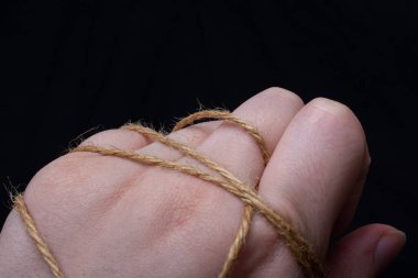 Bir dişinin eli ipe sarılı.