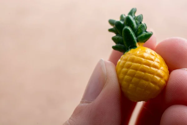 Hand Hält Eine Winzige Ananas Miniatur Auf Einem Ausgestellten Hintergrund — Stockfoto