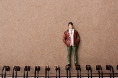 Spiral defterin yanında duran figür