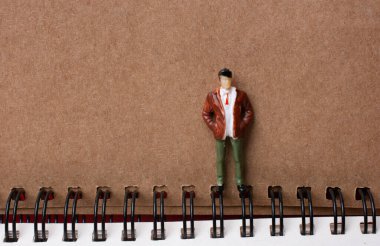 Spiral defterin yanında duran figür