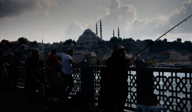 Golden Horn 'daki Galata Köprüsü' nde balık tutan adam.