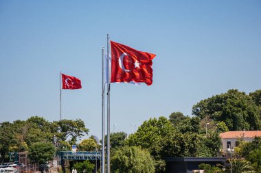 Arka planda mavi gökyüzü olan kırmızı Türk bayrakları.