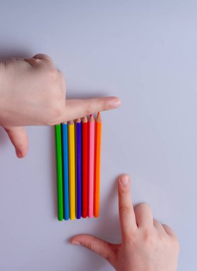 Beyaz arkaplana yerleştirilmiş el ele tutuşan kalemler